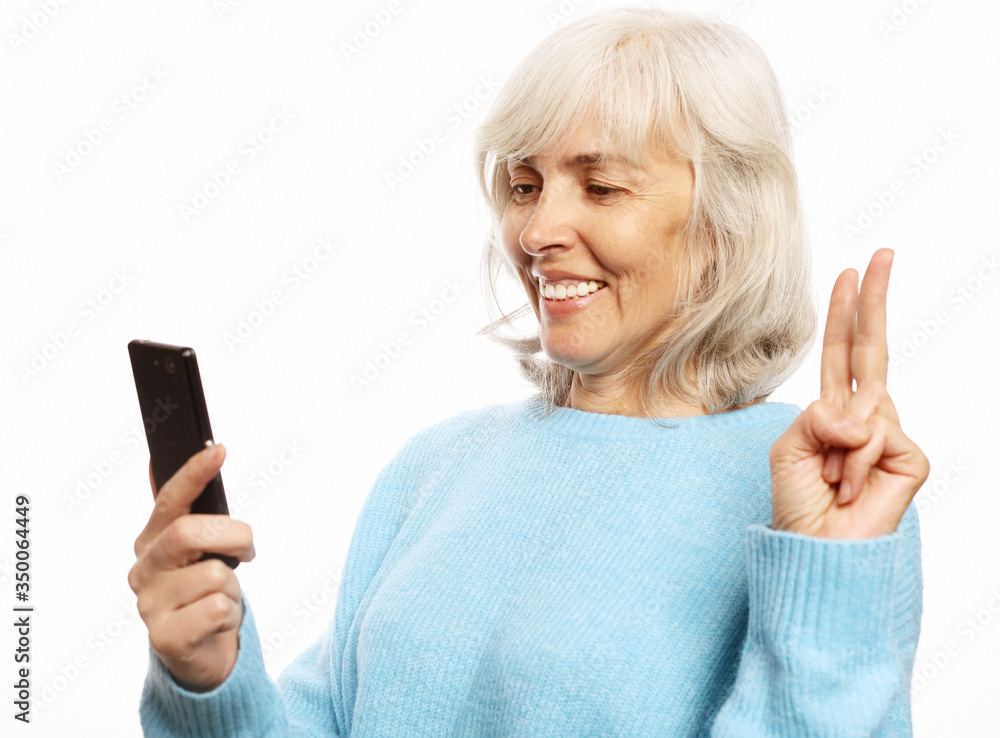 grandmother is talking to her grandchildren by phone, smiling and greeting them. grandmother is talking to her grandchildren by phone, smiling and greeting them.