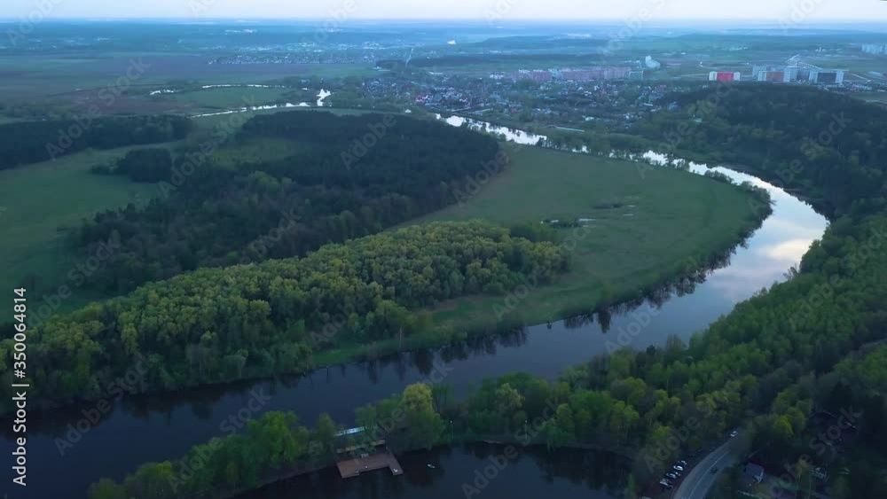 Flying over a lake or river crossing green islets. Dark foggy weather with clouds. Colorful view from above in 4K. End of day and sunset Flying over a lake or river crossing green islets. Dark foggy weather with clouds. Colorful view from above in 4K. End of day and sunset