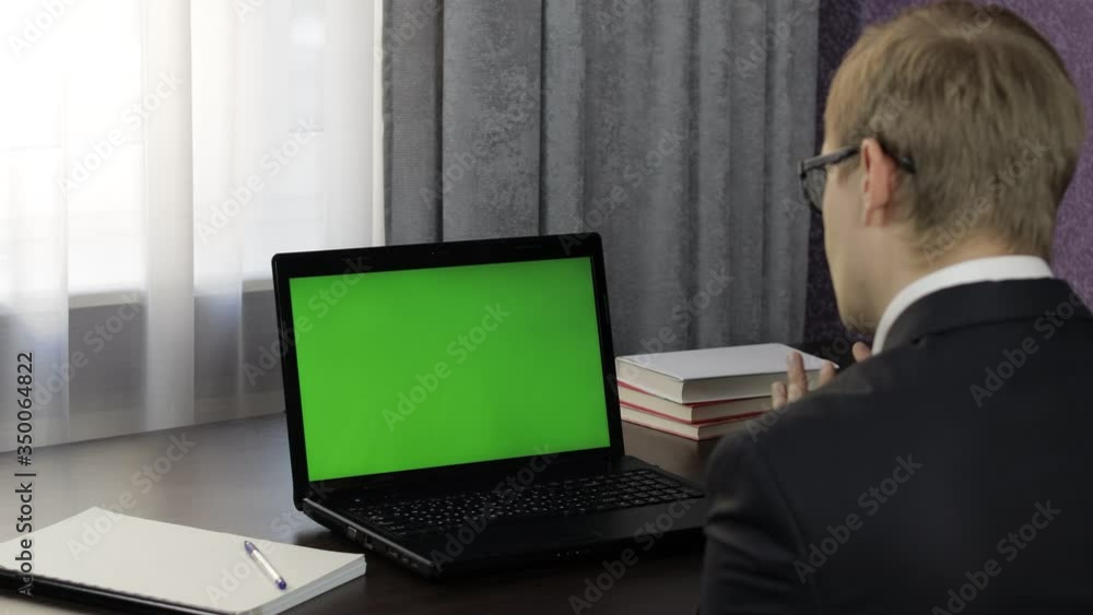 Man have video call conference on laptop with green screen. Distance work online Man have video call conference on laptop with green screen. Distance work online