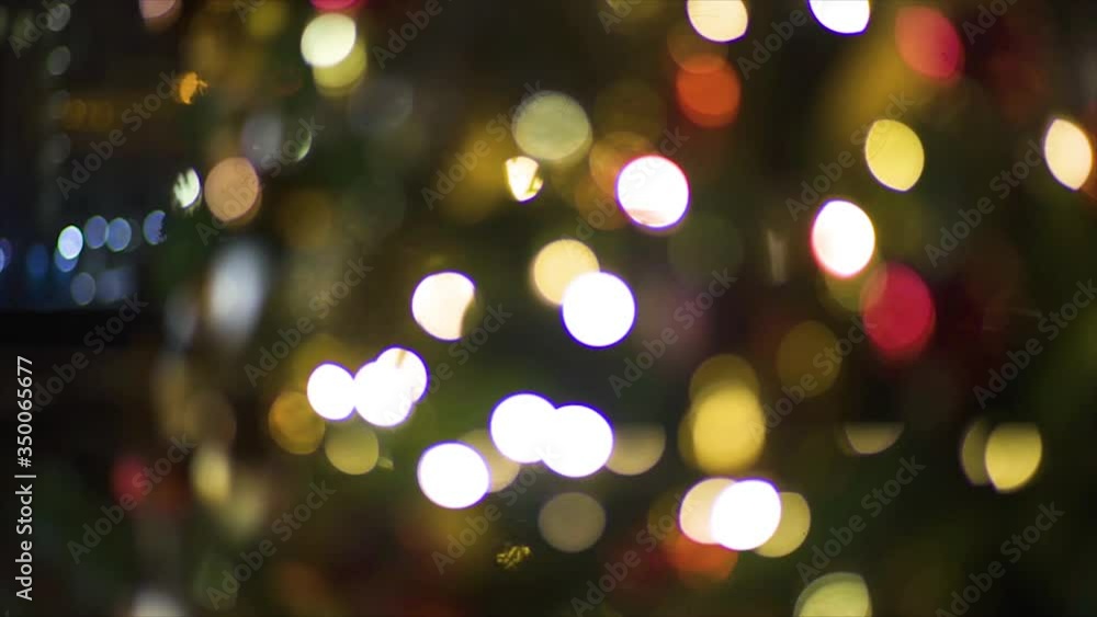 Close up a Christmas tree lights glittering at night. New Year fir tree with decorations and illumination. Xmas tree decorations background. Many large golden balls on fir tree New Year and Christmas. Close up a Christmas tree lights glittering at night. New Year fir tree with decorations and illumination. Xmas tree decorations background. Many large golden balls on fir tree New Year and Christmas.