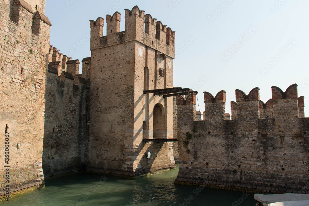 Walls and bridge across water moat at the Scaliger Castle entrance to old town, Sirmione, Lombardy, Italy.