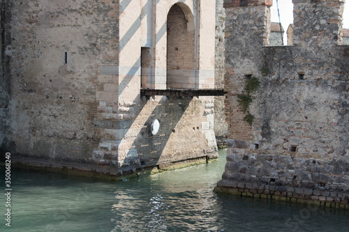 Walls and bridge across water moat at the Scaliger Castle entrance to old town, Sirmione, Lombardy, Italy.