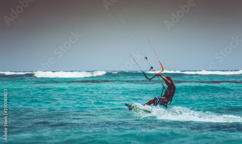 Xpu-ha, Quintana Roo, Mexico May 20, 2017 Man practicing kitesurfing on a turquoise blue water beach. 