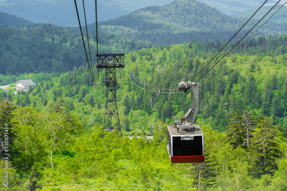 Cable Car to Mount Asahi (Asahi-dake) in summer with green forest. Mt Asahi is the tallest mountain in Hokkaido. Part of the Daisetsuzan Volcanic Group and located in the Daisetsuzan National Park.