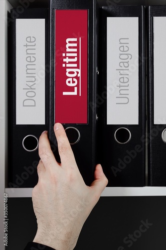 Legitim – Recht/Gesetz/Anwalt. Ordner im Regal. Hand nimmt Unterlagen aus Schrank. Beschriftung mit Text photo