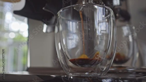 Close up of espresso coffee machine brewing extracting double shot into glass