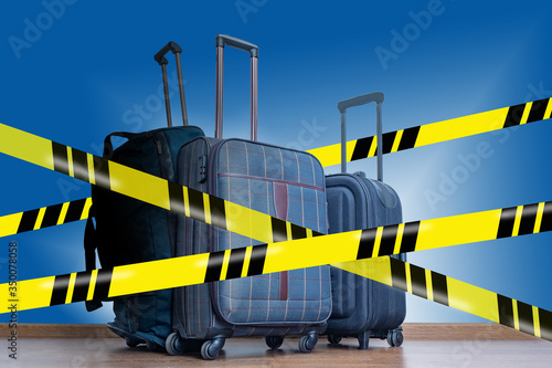 Suitcases on wheels behind a yellow security tape. Canceling trips and trips. Flight cancellation. Cancellation of vacation. Work without leave. Travel ban.