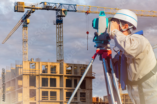 A surveyor works on a const...