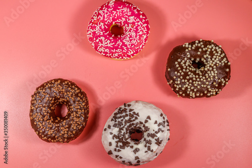 Tasty donuts on pink background. Top view