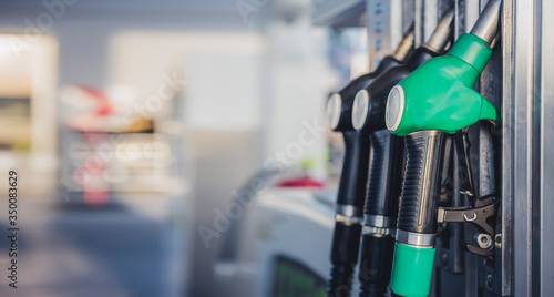 Tableau sur toile Woman pumping petrol with fuel pump at gas station
