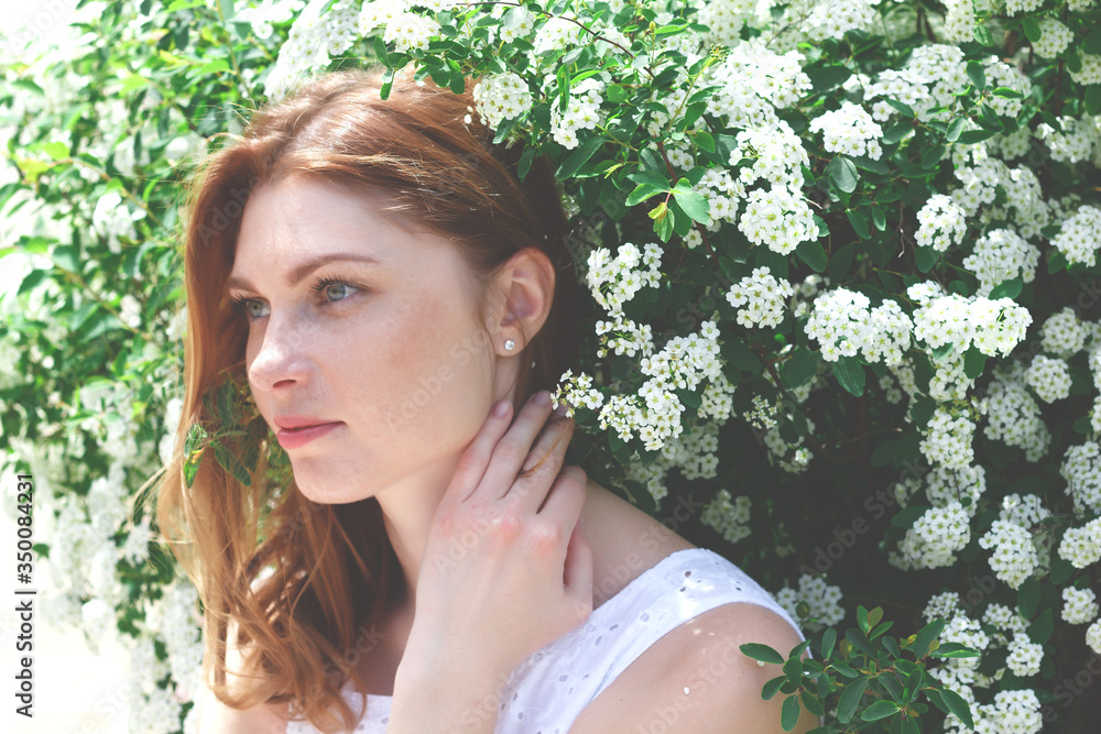 beautiful red-haired woman with freckles surrounded by white flowers beautiful red-haired woman with freckles surrounded by white flowers