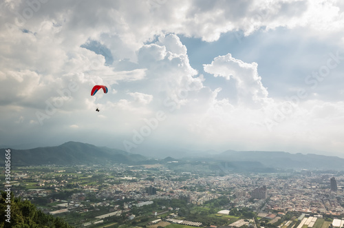 colorful paragliding over blue sky at town