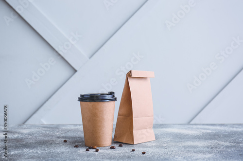 Paper bag and cup of coffee on table