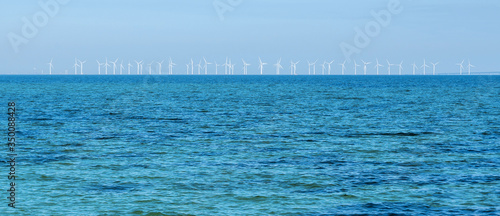 Wind turbine generating electricity on blue sea. Wind-driven generator in Baltic sea, Oresund strait