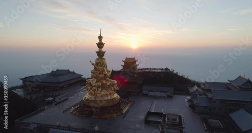 Aerial view of Emei mountain sunrise above the sea of clouds shining golden buddha statue on the peak of the mountain the UNESCO World Heritage site drone footage photo