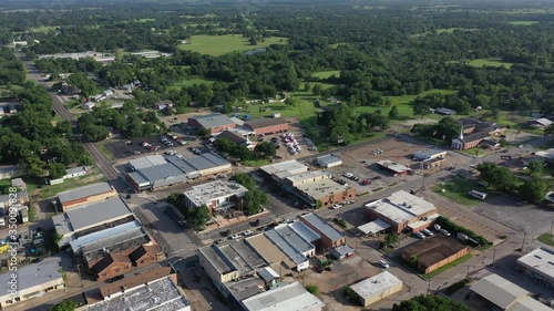 Flying over downtown buildings toward and church and rural area, Madisonville, Texas, USA photo