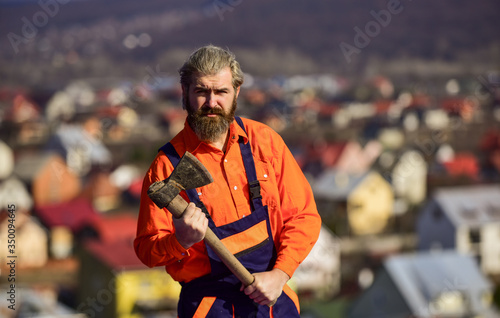 Man in uniform hold ax. Brutal bearded man axe in hands. Brutal and bearded. Builder with axe. Handsome guy brutal temper. Hard labour. Use axe construction. Renovation tools. Professional occupation © be free