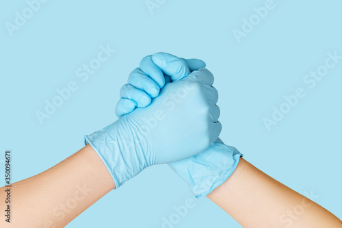 Hands of friends in medical gloves greeting each other. photo