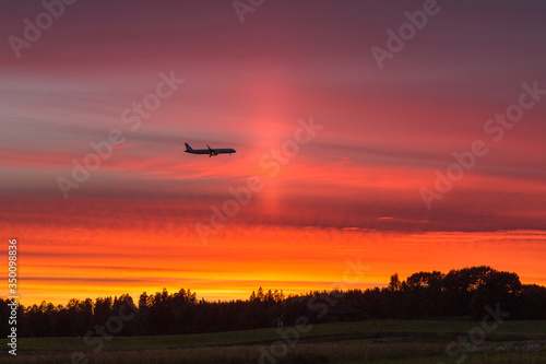 Airplane flying against the sunset © sokko_natalia
