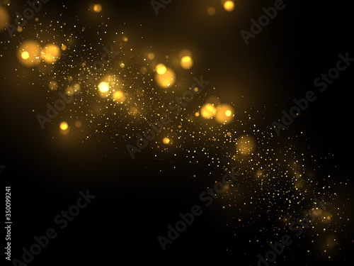 Glowing golden particles on black background