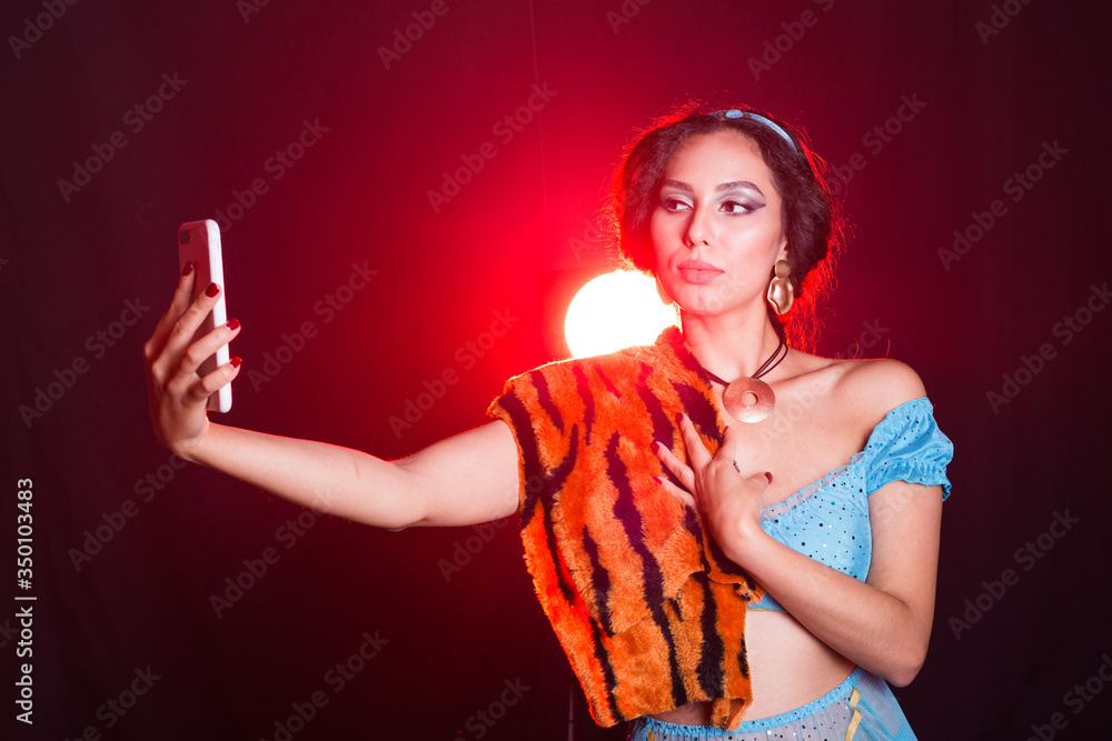 Girl doing selfie with tiger skin, crazy photos. Don't eco friendly lifestyle. Young woman takes pictures of herself in the phone. Life in social networks, narcissism, modern personality. Personality Girl doing selfie with tiger skin, crazy photos. Don't eco friendly lifestyle. Young woman takes pictures of herself in the phone. Life in social networks, narcissism, modern personality. Personality