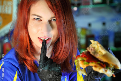 Girl with a juicy burger. Beautiful happy young woman with tasty burger on light background. Girl holds juicy cheeseburger.