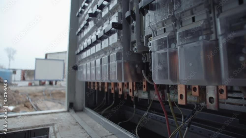 Inside of electrical control panel with multiple switches, wires, short