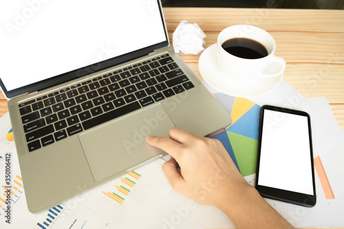 Close up hand of women using laptop for making plan of business and gedget on wooden table
