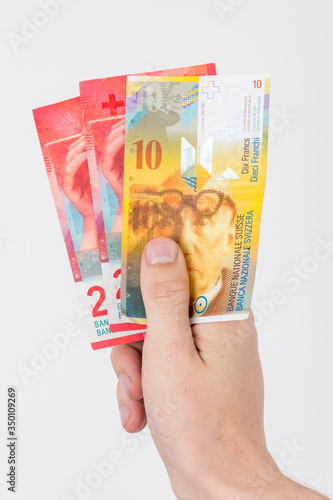 10 and 20 CHF Swiss franc banknotes in hand.
