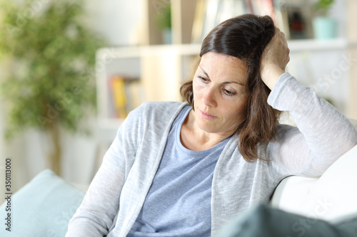Photography Sad pensive middle age woman looking down at home