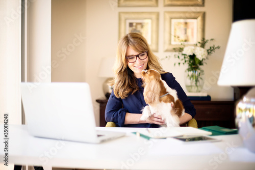 Confident mature woman using laptop while working from home