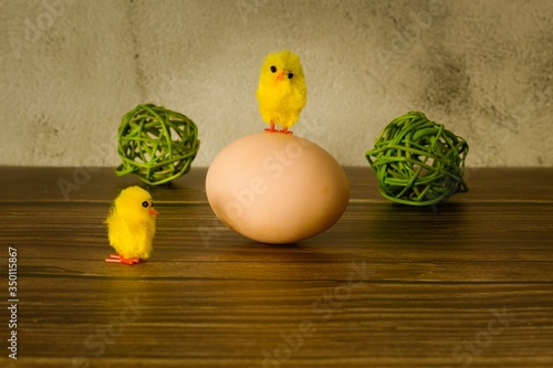 Beautiful Easter funny photo with hen egg, decorative balls and a small home-made chickens