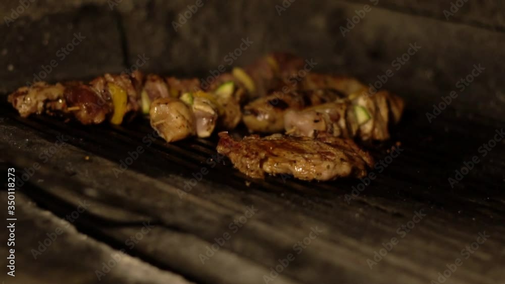 Cooking and frying pork skewers on the grill in a restaurant. Tasty meat is fried with seasonings on a fire, background, slow motion, appetizer Cooking and frying pork skewers on the grill in a restaurant. Tasty meat is fried with seasonings on a fire, background, slow motion, appetizer