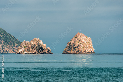 GURZUF, CRIMEA - View from a beach in Gurzuf on the famous rocks Adalary, Two Twin-Cliffs with an edge of mountain Au-Dag in early spring morning at the South coast of Crimean Peninsula. Copy space. photo