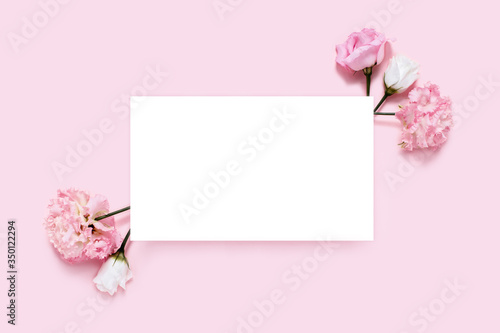 Greeting horizontal picture. Holiday card. Pink background with sheet of white paper and flowers. © Aleksandra Abramova