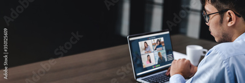 Work from home with asian businessman video conference collaboration with colleagues.live streaming meeting.banner mockup for display of content photo