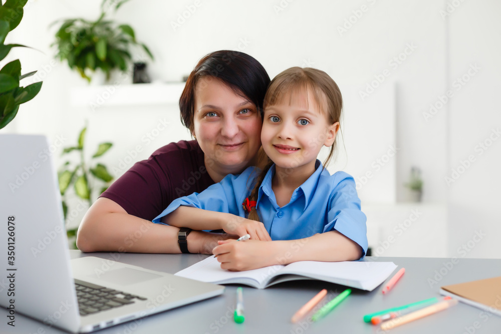 Remote lessons. The child smiles happily and gets knowledge remotely. Little girl study online learning from home. Online school. Remote lessons. The child smiles happily and gets knowledge remotely. Little girl study online learning from home. Online school.