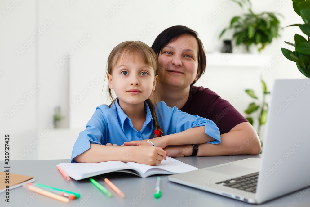 Remote lessons. The child smiles happily and gets knowledge remotely. Little girl study online learning from home. Online school. Remote lessons. The child smiles happily and gets knowledge remotely. Little girl study online learning from home. Online school.