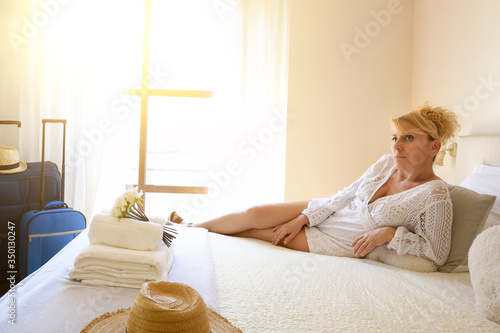 Woman on vacation relaxed and lying on a bed
