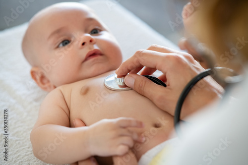 фотографія Close up of doctor hand checking cute baby