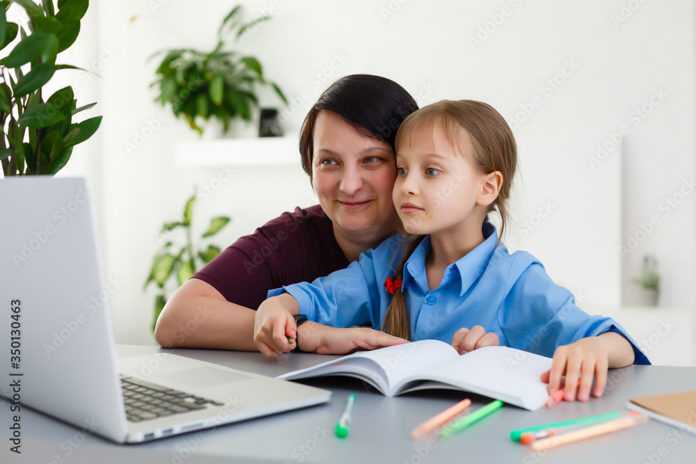 Remote lessons. The child smiles happily and gets knowledge remotely. Little girl study online learning from home. Online school. Remote lessons. The child smiles happily and gets knowledge remotely. Little girl study online learning from home. Online school.