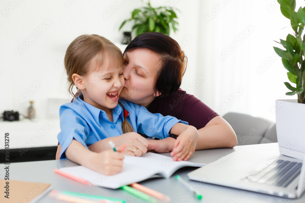 Remote lessons. The child smiles happily and gets knowledge remotely. Little girl study online learning from home. Online school. Remote lessons. The child smiles happily and gets knowledge remotely. Little girl study online learning from home. Online school.