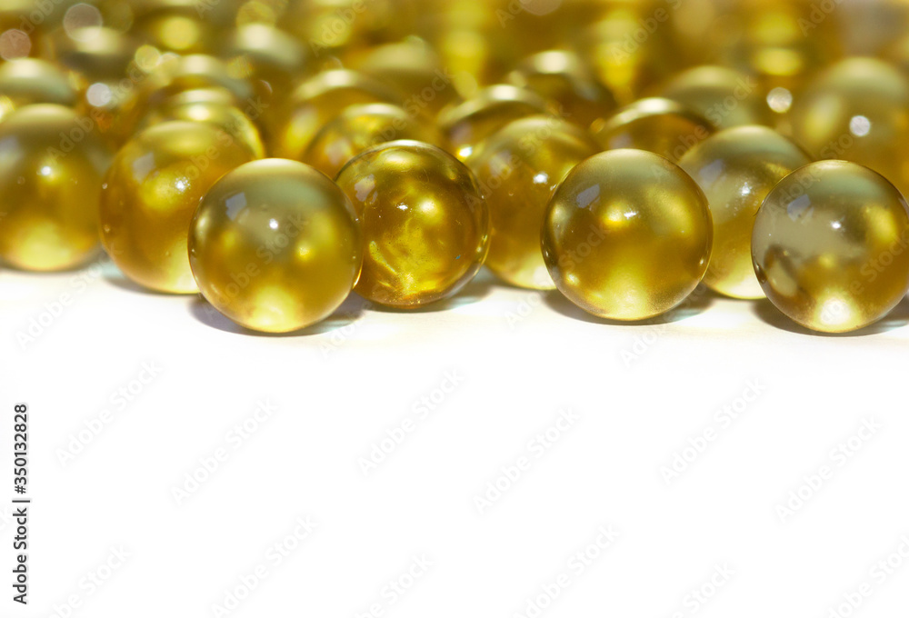 Yellow fish oil in capsules on a white background. Omega3 vitamins close-up. Capsules fish oil macro. Vitamins for health. Yellow fish oil in capsules on a white background. Omega3 vitamins close-up. Capsules fish oil macro. Vitamins for health.
