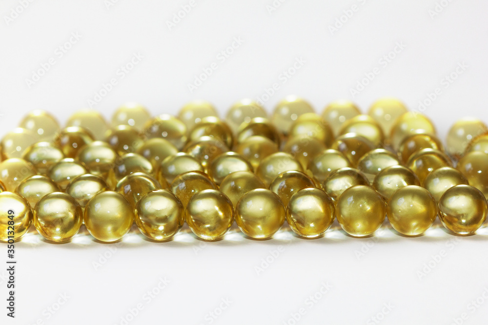 Yellow fish oil in capsules on a white background. Omega3 vitamins close-up. Capsules fish oil macro. Vitamins for health. Yellow fish oil in capsules on a white background. Omega3 vitamins close-up. Capsules fish oil macro. Vitamins for health.