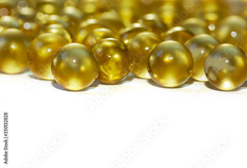Yellow fish oil in capsules on a white background. Omega3 vitamins close-up. Capsules fish oil macro. Vitamins for health.