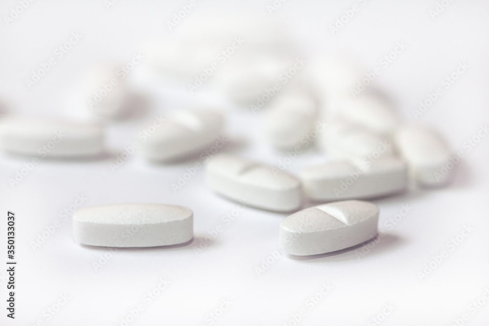 White pills on a white background close-up. Painkillers. A remedy for the Covid19 virus. Tablet macro. Copy space. White pills on a white background close-up. Painkillers. A remedy for the Covid19 virus. Tablet macro. Copy space.