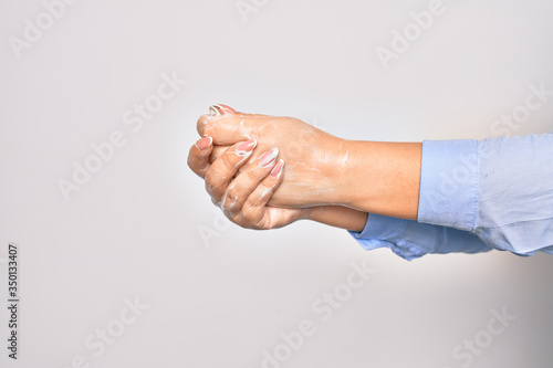 Young caucasian woman cleaning hands using alcohol liquid over isolated white background