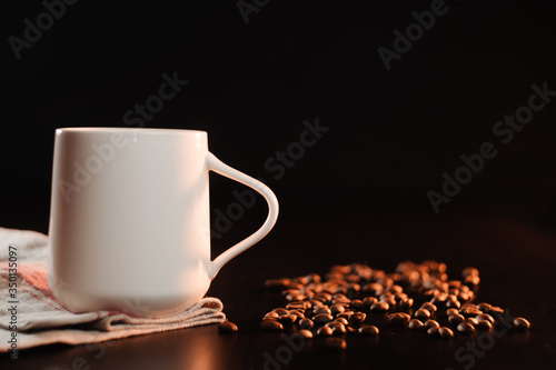 A white beautiful cup of tea or freshly brewed coffee is standing on a beautiful rag