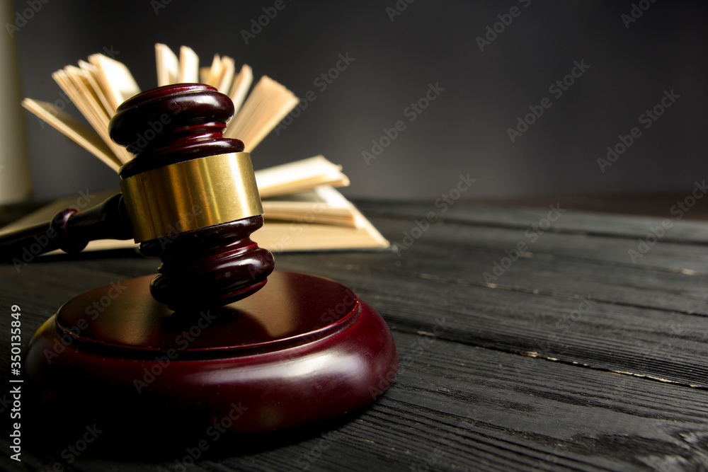 Law concept - Open law book with a wooden judges gavel on table in a courtroom or law enforcement office isolated on white background. Copy space for text Law concept - Open law book with a wooden judges gavel on table in a courtroom or law enforcement office isolated on white background. Copy space for text
