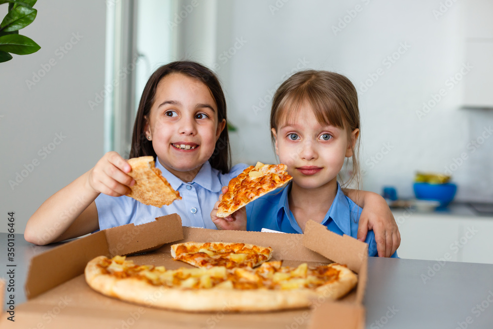 Two happy little child girl friends eating pizza slices. Two happy little child girl friends eating pizza slices.